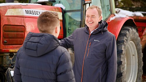 Tim stood by a tractor